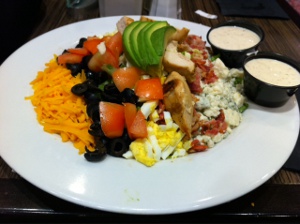Cobb Salad (olives, tomatoes, avocado, bacon, chicken, eggs, blue cheese, cheddar cheese) with Caesar dressing
